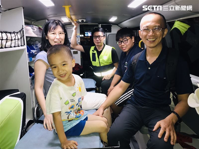 一家人坐在救護車上合影留念。（圖／翻攝畫面）